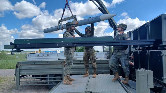 Militares españoles cargan un misil en la batería «Nasams» de Letonia