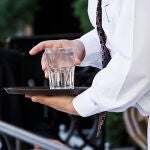 Un camarero con un vaso de agua