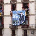 Miembros de las Juventudes Nacionalistas de Cataluña (JNC) cuelgan una pancarta alusiva al ex presidente Carles Puigdemont durante la primera diada castellera de la Mercè 2024 en la Plaça de Sant Jaume de Barcelona durante las fiestas de La Mercè.