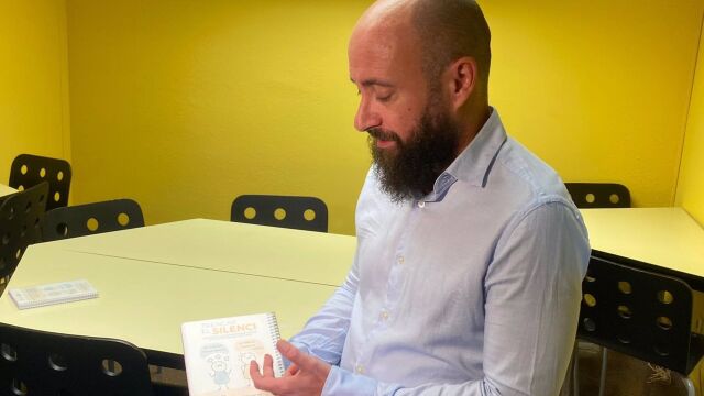 El coordinador del equipo de protección a la infancia de Maristes Catalunya, Raúl García, muestra una agenda con un código QR con un acceso directo al canal de denuncia