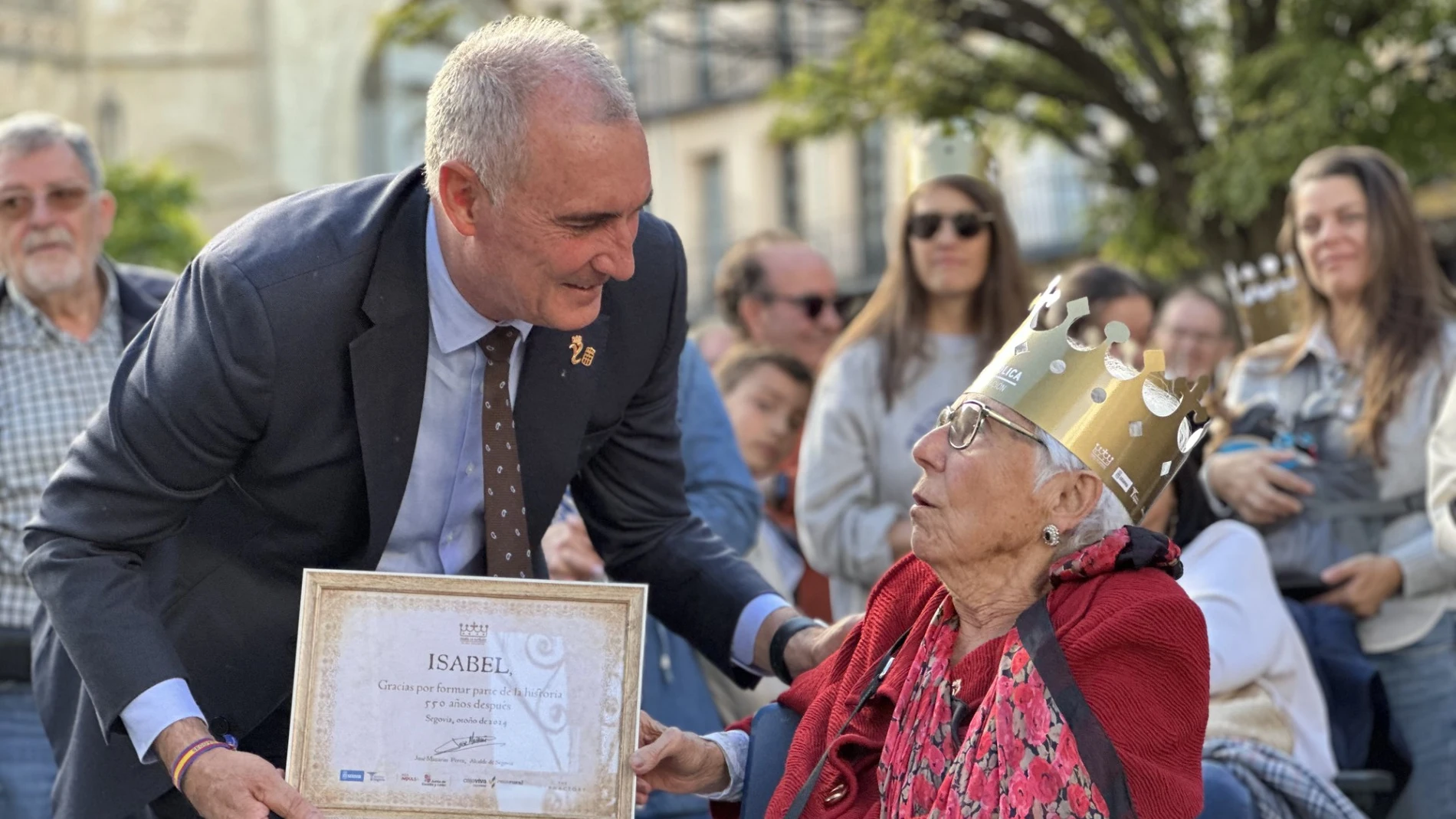 El alcalde de Segovia, José Mazarías, entrega un distintivo a una de las "Isabeles"