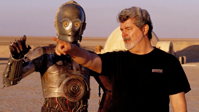In this undated publicity photo released by Lucasfilm Ltd. & TM, director George Lucas directs actor Anthony Daniels, who plays the robot C-3PO, in "Star Wars II: Attack of the Clones," on location in the Tunisian desert.