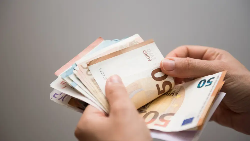 Persona contando un fajo de billetes de euros