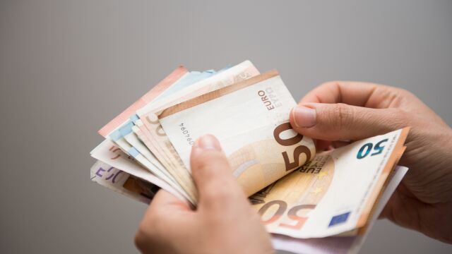 Persona contando un fajo de billetes de euros