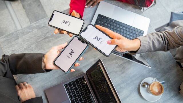 Three businesswomen during a meeting pay the bill with Bizum, a fast money exchange system.