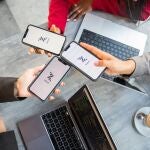 Three businesswomen during a meeting pay the bill with Bizum, a fast money exchange system.