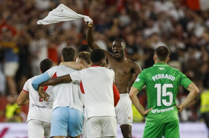 Los jugadores del Sevilla celebran el triunfo ante la desolación bética