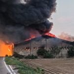Un incendio que afecta desde primera hora de este domingo a una nave ubicada en el Camí Assagador de Vera, en el término municipal de Alboraia (Valencia).