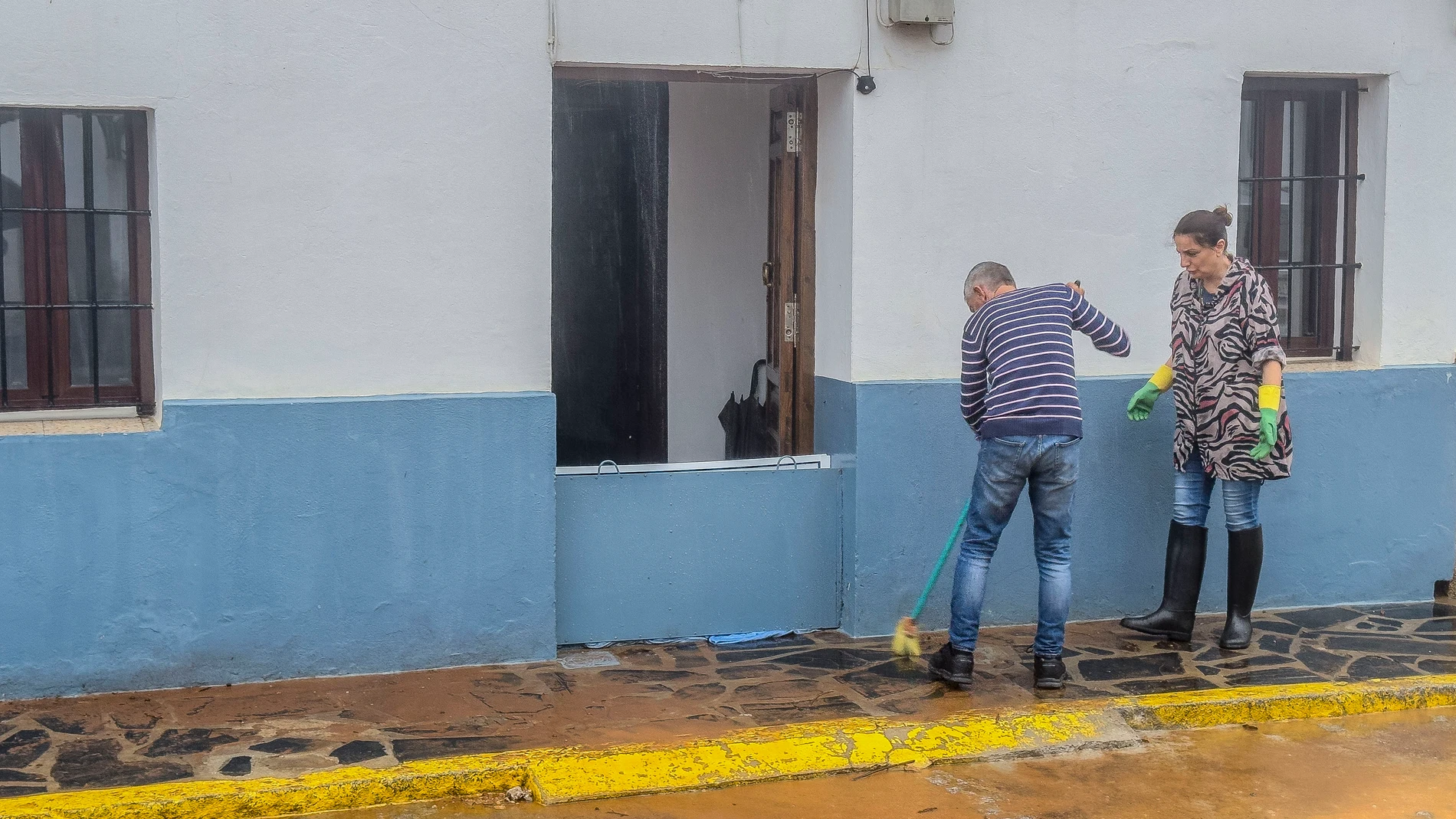 CONSTANTINA (SEVILLA), 12/10/2024.-Vecinos limpian una calle del pueblo de Constantina, en la sierra norte de Sevilla, donde este sábado las fuertes lluvias han provocado que algunas de sus calles se conviertan en ríos de agua y barro. La borrasca Berenice ha dejado precipitaciones muy intensas durante las primeras horas del día en el suroeste peninsular, que motivaron la activación de la alerta "roja" (riesgo extremo) en las provincias de Sevilla y Córdoba, y las copiosas lluvias se han exte...