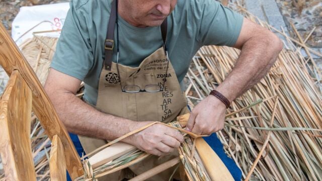 Un artesano de la madera de olivo realiza una silla durante la Feria Ars Olea