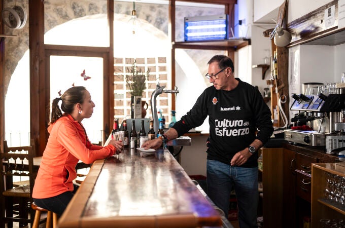 Marina Albesa, conversa con Pedro Silvestre, quien forma parte del proyecto Àmbit de reinserción sociolaboral, en el bar del Mesón de Herbers donde los integrantes del proyecto aprenden a gestionar un negocio de hosteleria