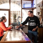 Marina Albesa, conversa con Pedro Silvestre, quien forma parte del proyecto Àmbit de reinserción sociolaboral, en el bar del Mesón de Herbers donde los integrantes del proyecto aprenden a gestionar un negocio de hosteleria