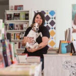 Beatriz Martín Ballesteros, dueña de la librería Balqís, posa el pasado 21 de octubre junto a su perra, Phoebe, en su nuevo local de la calle Baños de Montemayor, 7.