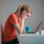 Mujer consultando en su portatil lo que bien podría ser un chat de IA