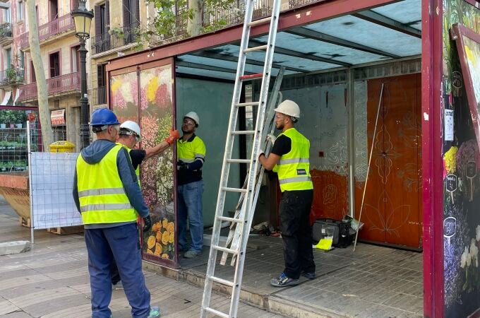 Operarios desmontan una parada de flores de la Rambla este martes.