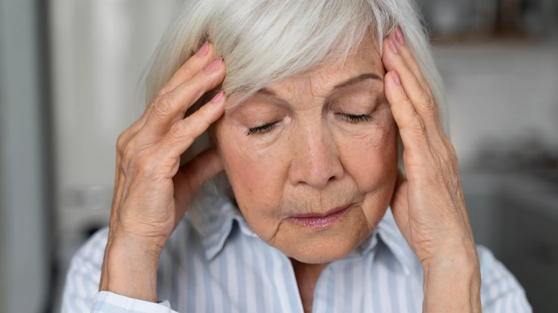Mujer se sujeta la cabeza como si tuviera problemas de memoria longevidad envejecimiento cerebral