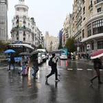 Viandantes se protegen de la lluvia con paraguas por el centro de Madrid. Imagen de archivo