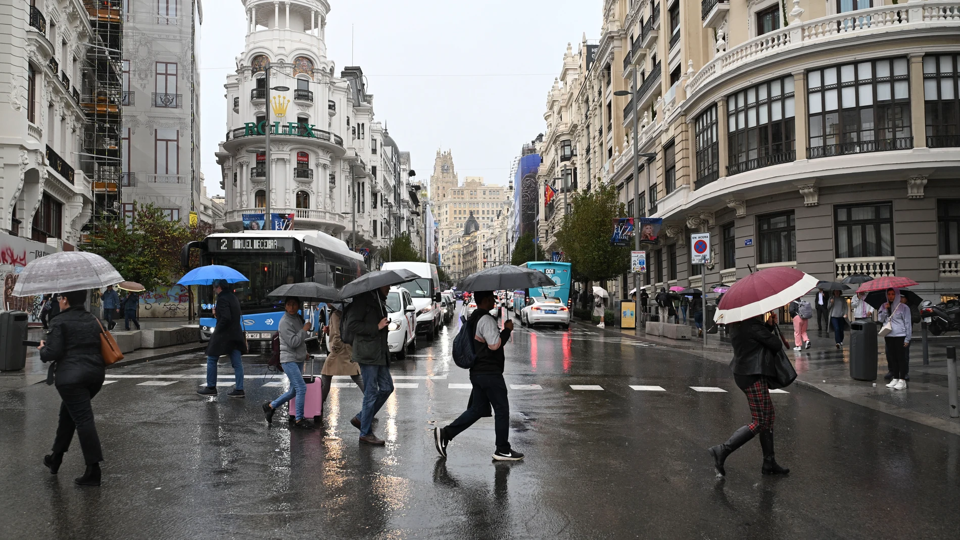 Viandantes se protegen de la lluvia con paraguas por el centro de Madrid. Imagen de archivo