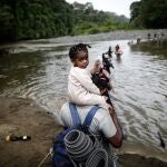 DARIÉN (PANAMÁ), 20/12/2023.- Migrantes cruzan el río Turquesa, el 14 de septiembre de 2023 ,en Darién (Panamá). Horrible, horrible, repiten muchos migrantes. El paso por la selva del Darién, la frontera natural entre Panamá y Colombia, no es como imaginaron. Guiados por videos que inundan las redes sociales y el relato de conocidos, la desinformación y el engaño acentúan la crisis migratoria. EFE/ Bienvenido Velasco