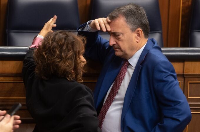 La vicepresidenta segunda y ministra de Hacienda, María Jesús Montero y el portavoz del PNV, Aitor Esteban, conversan durante una sesión plenaria, en el Congreso de los Diputados, a 30 de octubre de 2024, en Madrid (España).