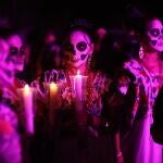 Personas disfrazadas de catrinas participan en el tradicional Paseo de las Ánimas, este jueves en Mérida (México). El Paseo de las Ánimas es una tradición en la que las personas portan el traje regional del estado de Yucatán con la cara pintada de calaveras para recordar sus seres queridos en el Día de Muertos. 