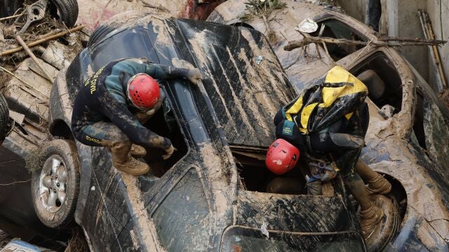 PAIPORTA (VALENCIA), 02/11/2024.- Expertos de la Guardia Civil buscan cuerpos sin vida entre los vehículos atrapados entre los cimientos de un edificio en construcción, este sábado, en Paiporta, Valencia. / 