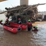 Bomberos y efectivos de la UME buscan víctimas de la DANA en el nuevo cauce del río Turia en Valencia