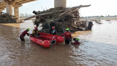Bomberos y efectivos de la UME buscan víctimas de la DANA en el nuevo cauce del río Turia en Valencia