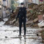 Un miembro de la Policía Nacional junto a una montaña de escombros en Catarroja, Valencia