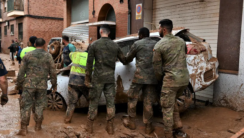 Efectivos del Ejército de Tierra retiran un vehículo para abrir la circulación de vehículos y personas en las calles de Aldaia y Algemesí