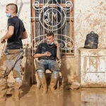 Voluntarios barren el lodo de una calle de Masanasa, Valencia, hoy jueves