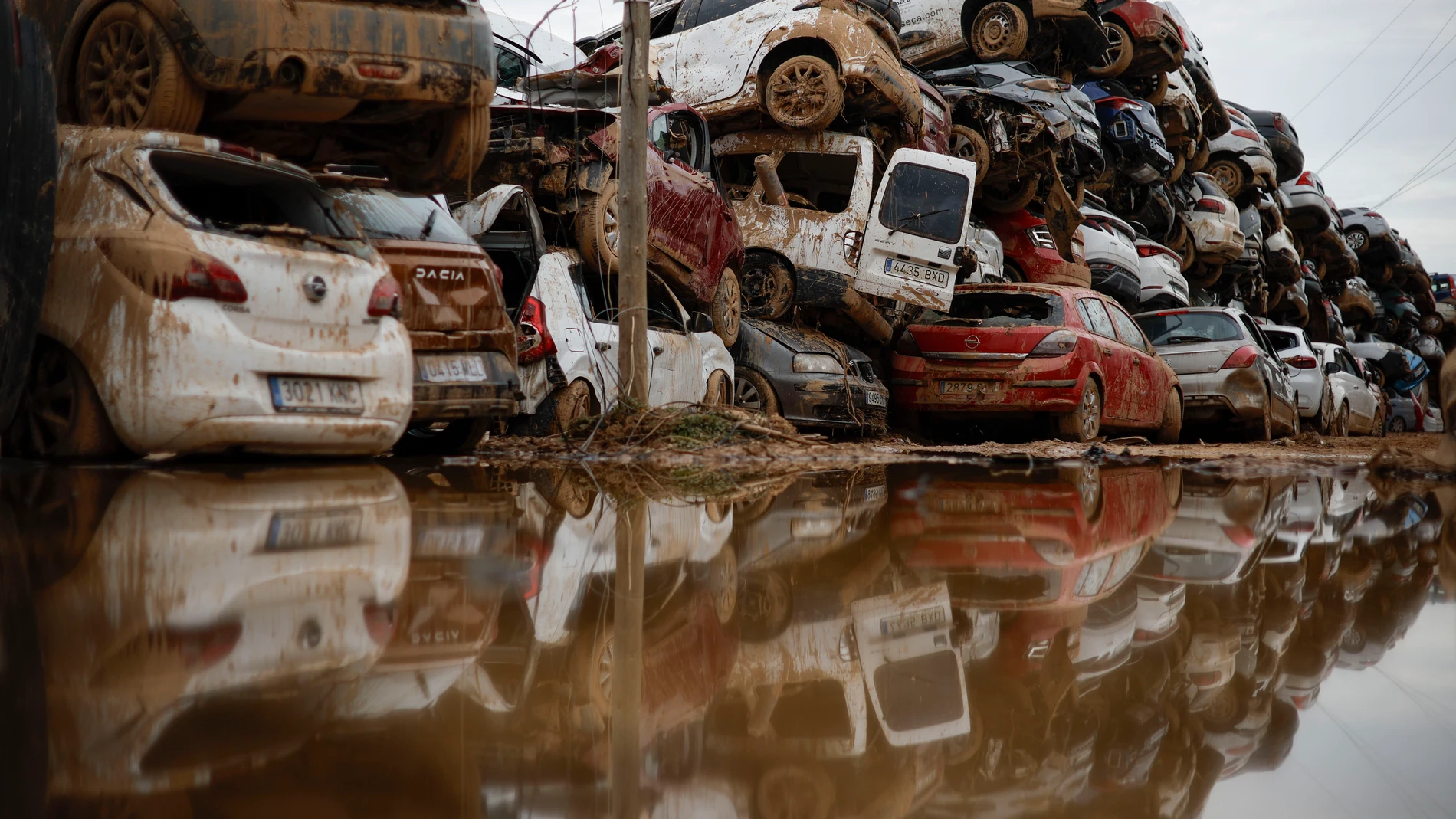 PAIPORTA (VALENCIA), 08/11/2024.- Varios coches, que fueron arrastrados por el agua tras el paso de la dana, almacenados en un descampado en Paiporta este viernes. La Unidad Militar de Emergencias (UME) sitúa en los municipios valencianos de Paiporta, Chiva, Catarroja y Massanassa la situación "más crítica" por la dana y que está requiriendo un mayor número de actuaciones por parte de las fuerzas armadas que trabajan en casi 600 misiones diferentes en 72 localidades. EFE/ Biel Aliño