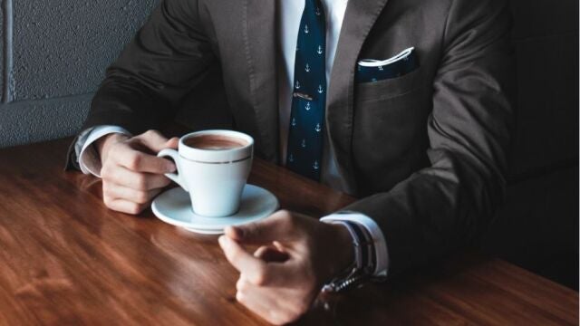 Una persona con una taza llena de café