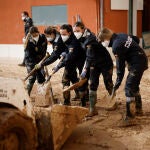 Un grupo de estudiantes de la Policía Nacional trabajan en las calles de Masanasa, este martes, pertrechadas con mascarillas