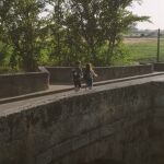 Dos peregrinos cruzan el Puente Canto de Sahagún, junto al cual creció una chopera frondosa de las raíces de las lanzas, según la leyenda