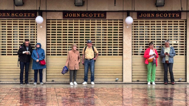 Turistas se resguardan de la lluvia en la zona de la Plaza de la Constitución de la capital malagueña, a media mañana del miércoles