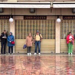 Turistas se resguardan de la lluvia en la zona de la Plaza de la Constitución de la capital malagueña, a media mañana del miércoles