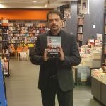 El escritor madrileño Juan Solo posa con su última novela "Los crímenes del carrusel" en la librería Oletvm de Valladolid