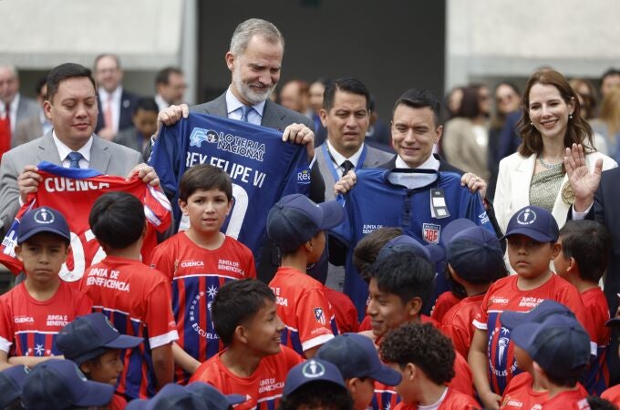 El rey Felipe VI (2-i) posa junto al presidente de Ecuador, Daniel Noboa (2-d), y la primera dama de Ecuador, Lavinia Valbonesi (d), en la inauguración de una nueva escuela del Atlético de Madrid este jueves, en Cuenca (Ecuador). El Atlético de Madrid inaugura una nueva escuela en Ecuador bajo el convenio desarrollado con la Junta de Beneficencia de Guayaquil. 