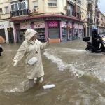 Una mujer hace fotos con el agua hasta las rodillas en Málaga donde las fuertes trombas de agua y granizo que se registran este miércoles han causado inundaciones y la acumulación de grandes balsas en algunas de las principales avenidas de todos los distritos de la ciudad.