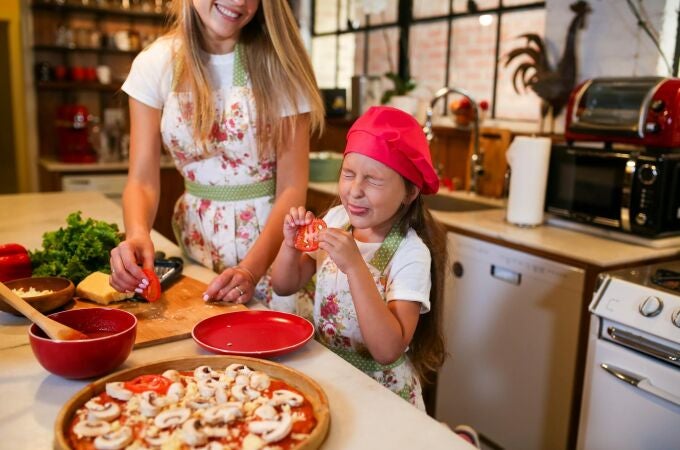 Niña haciendo una pizza de setas