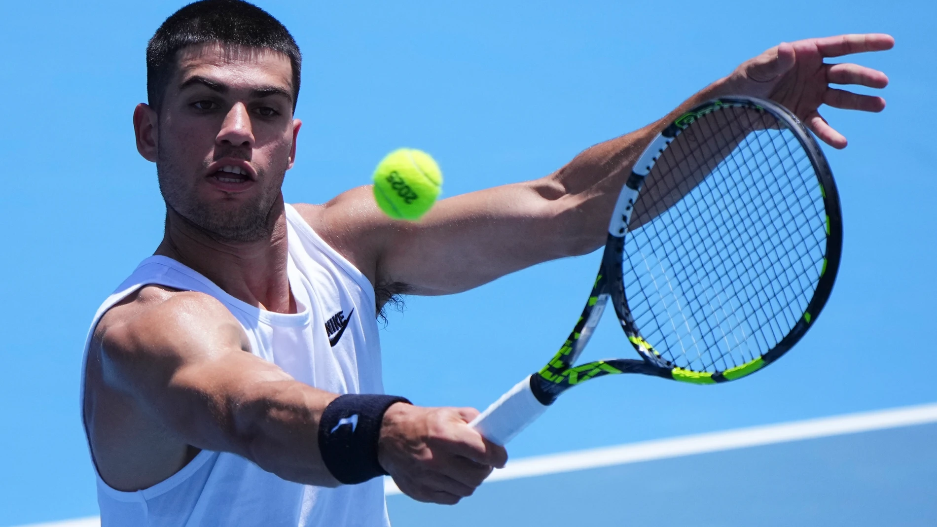 Spain's Carlos Alcaraz plays a backhand return during a practice session ahead of the Australian Open tennis championship in Melbourne, Australia, Friday, Jan. 10, 2025. (AP Photo/Vincent Thian)