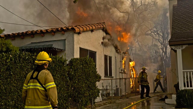 Los bomberos de Los Ángeles trabajando en una de las viviendas afectadas