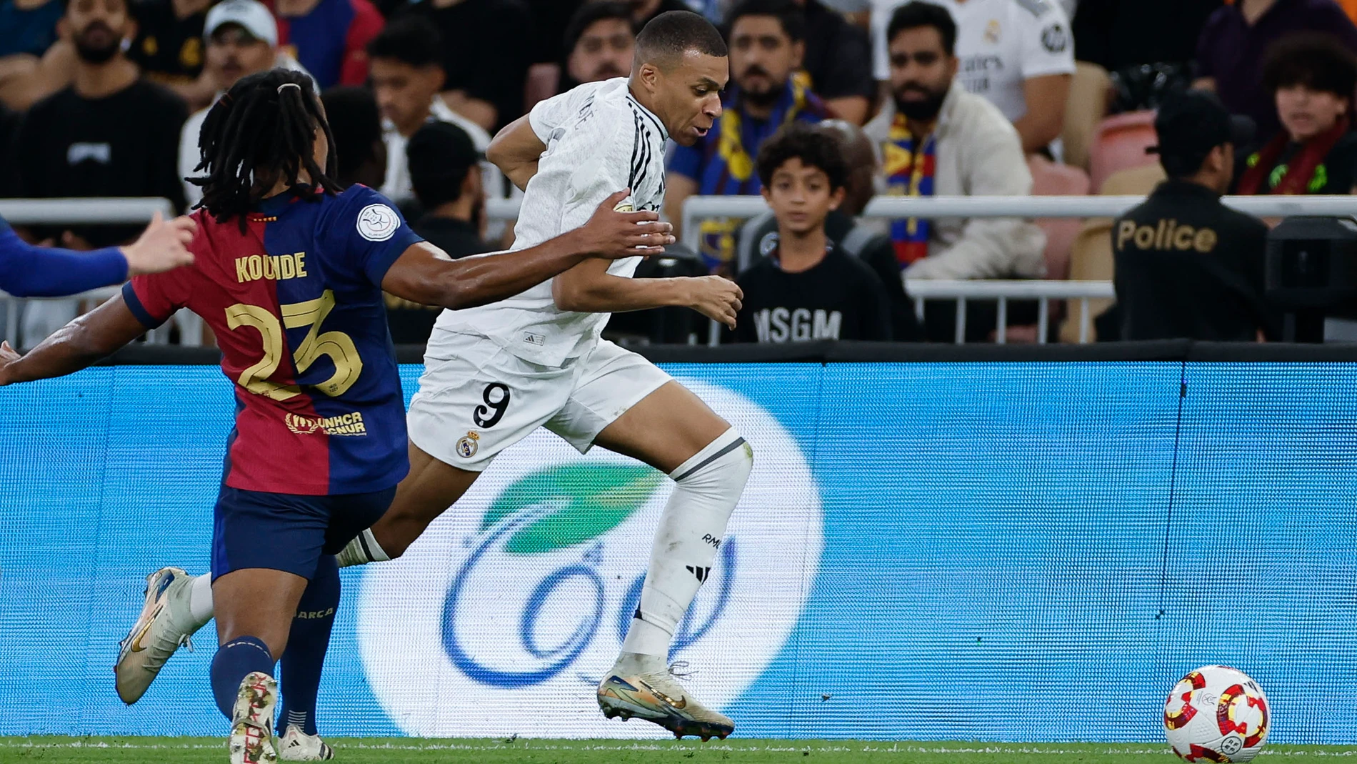 YEDA (ARABIA SAUDÍ), 12/01/2025.- El delantero francés del Real Madrid Kylian Mbappé (d) se escapa de Jules Koundé, del FC Barcelona, durante el partido de la final de la Supercopa de España de fútbol entre el Real Madrid y el FC Barcelona, este domingo en Yeda, Arabia Saudí. EFE/ Alberto Estévez