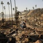 Kevin Marshall sifts through his mother's fire-ravaged property in the the Palisades Fire in the Pacific Palisades neighborhood of Los Angeles, Saturday, Jan. 11, 2025. (AP Photo/John Locher)