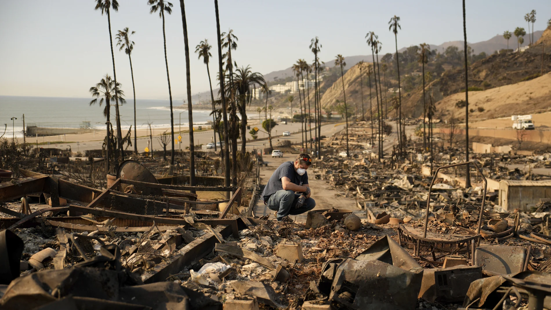 Kevin Marshall sifts through his mother's fire-ravaged property in the the Palisades Fire in the Pacific Palisades neighborhood of Los Angeles, Saturday, Jan. 11, 2025. (AP Photo/John Locher)