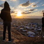 Palestinos observan la puesta de sol en el sur de la Franja de Gaza