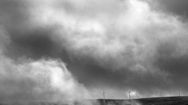 Molino de viento entre nubes del paisaje en la Sierra de Ojos de Albos, Avila.