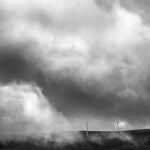 Molino de viento entre nubes del paisaje en la Sierra de Ojos de Albos, Avila.