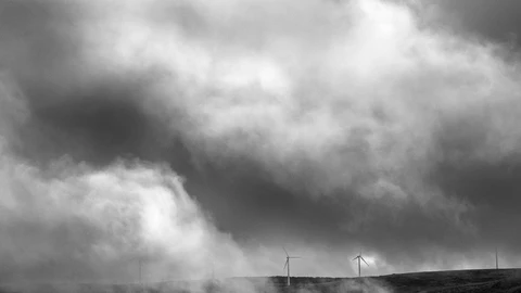 Molino de viento entre nubes del paisaje en la Sierra de Ojos de Albos, Avila.